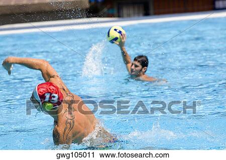 Mid adult man and a young man playing water polo in a swimming pool View Large Photo Image Stock Image - Mid adult man and a young man playing water polo in a swimming pool. Fotosearch