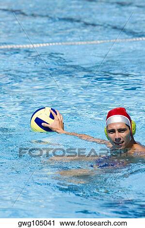 Mid adult man playing water polo in a swimming pool View Large Photo Image Stock Image - Mid adult man playing water polo in a swimming pool. Fotosearch