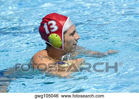 Stock Photograph - Mid adult man playing water polo in a swimming pool. Fotosearch