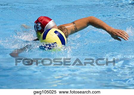 Stock Photography - Mid adult man playing water polo in a swimming pool. Fotosearch