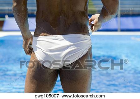 Rear view of a mid adult man holding swimming goggles View Large Photo Image Stock Photo - Rear view of a mid adult man holding swimming goggles. Fotosearch