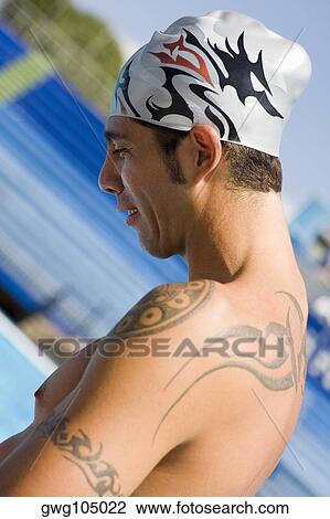 Stock Image - Side profile of a mid adult man at the poolside. Fotosearch