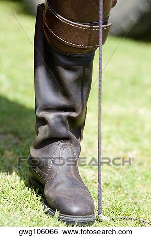Close-up of a person's leg wearing a riding boot View Large Photo Image Stock Photograph - Close-up of a person's leg wearing a riding boot. Fotosearch
