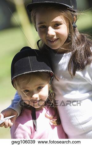 Close-up of two girls wearing riding hats and smiling View Large Photo Image Stock Photo - Close-up of two girls wearing riding hats and smiling. Fotosearch
