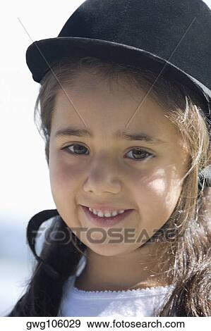Stock Photo - Portrait of a girl wearing a riding hat and smiling. Fotosearch
