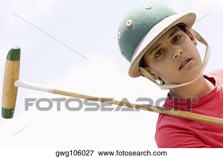 Portrait of a teenage boy holding a polo mallet View Large Photo Image Stock Photo - Portrait of a teenage boy holding a polo mallet. Fotosearch