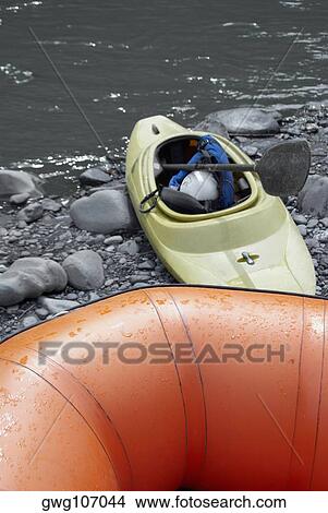 Picture - Close-up of an inflatable raft and a kayak at a riverbank. Fotosearch
