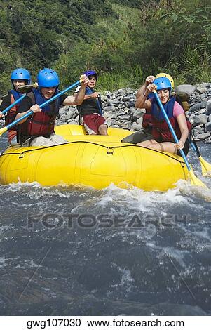 Stock Image - Five people rafting in a river. Fotosearch