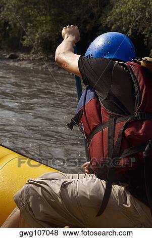 Stock Photo - Side profile of a person rafting in a river. Fotosearch