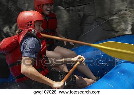 Side profile of a young couple rafting View Large Photo Image Stock Photo - Side profile of a young couple rafting. Fotosearch