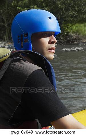 Side profile of a young man rafting in a river View Large Photo Image Stock Photo - Side profile of a young man rafting in a river. Fotosearch