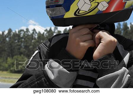 Close-up of a person adjusting his crash helmet View Large Photo Image Stock Image - Close-up of a person adjusting his crash helmet. Fotosearch