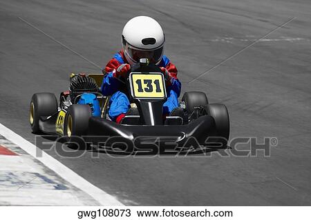 Stock Image - Person go-carting on a motor racing track. Fotosearch