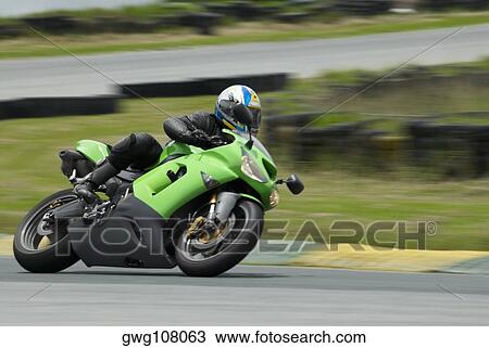Person riding a motorcycle on a motor racing track View Large Photo Image Stock Image - Person riding a motorcycle on a motor racing track. Fotosearch