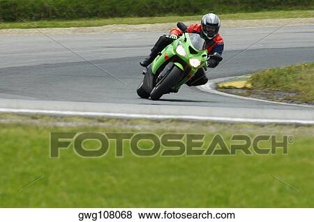 Person riding a motorcycle on a motor racing track View Large Photo Image Stock Photo - Person riding a motorcycle on a motor racing track. Fotosearch