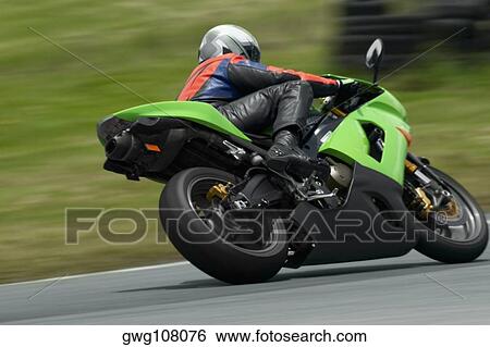 Stock Photograph - Person riding a motorcycle on a motor racing track. Fotosearch