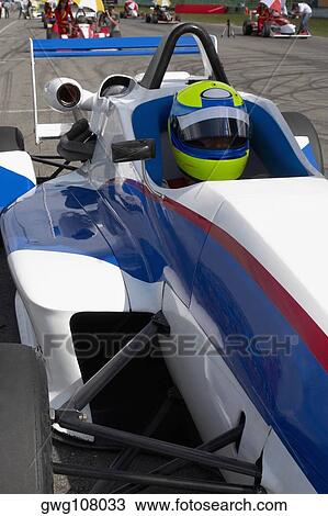 Stock Image - Racecar driver sitting in a racecar. Fotosearch