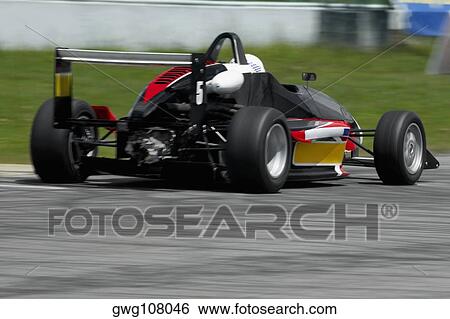 Racecar racing on a motor racing track View Large Photo Image Stock Photograph - Racecar racing on a motor racing track. Fotosearch