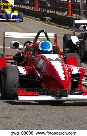 Racecars racing on a motor racing track View Large Photo Image Stock Photo - Racecars racing on a motor racing track. Fotosearch
