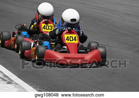 Two people go-carting on a motor racing track View Large Photo Image Stock Photo - Two people go-carting on a motor racing track. Fotosearch