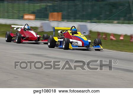 Two racecars racing on a motor racing track View Large Photo Image Stock Photo - Two racecars racing on a motor racing track. Fotosearch