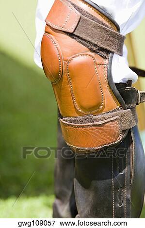 Close-up of a person's legs wearing riding boots and a kneepad View Large Photo Image Stock Photo - Close-up of a person's legs wearing riding boots and a kneepad. Fotosearch