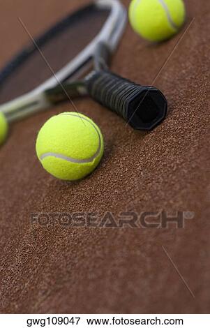 Close-up of three tennis balls and a racket in a court View Large Photo Image Stock Photo - Close-up of three tennis balls and a racket in a court. Fotosearch