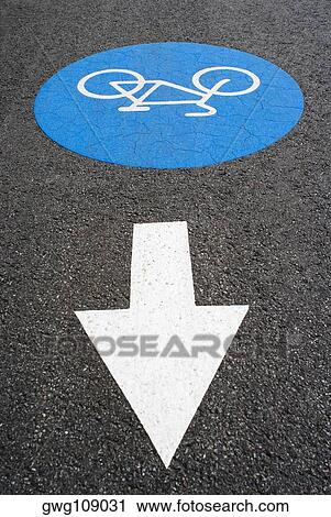 Stock Image - High angle view of an arrow sign at a bicycle lane. Fotosearch