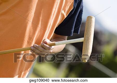Mid section view of a man holding a polo mallet View Large Photo Image Stock Image - Mid section view of a man holding a polo mallet. Fotosearch