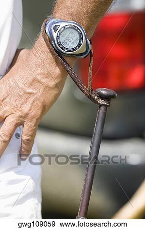 Polo mallet hanging from a wristwatch of a man View Large Photo Image Stock Photo - Polo mallet hanging from a wristwatch of a man. Fotosearch