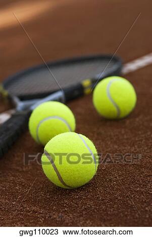 Close-up of three tennis balls and a racket in a court View Large Photo Image Stock Image - Close-up of three tennis balls and a racket in a court. Fotosearch