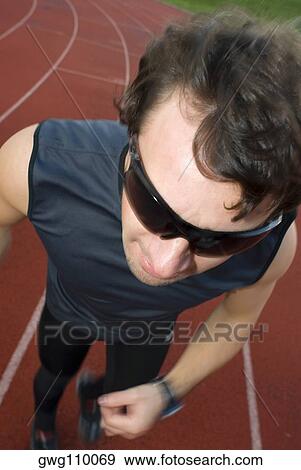 Stock Photo - High angle view of a mid adult man running on a running track. Fotosearch