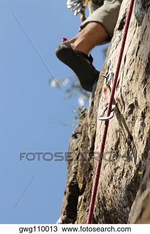 Low section view of a rock climber scaling a rock face View Large Photo Image Stock Image - Low section view of a rock climber scaling a rock face. Fotosearch