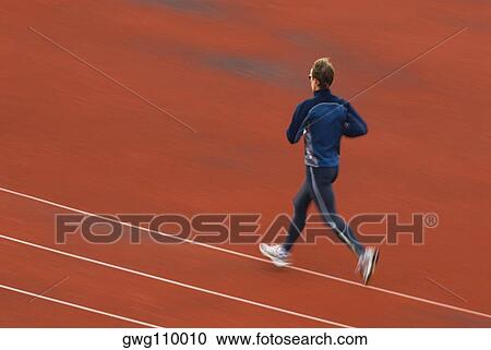 Rear view of a mid adult man running on a running track View Large Photo Image Stock Image - Rear view of a mid adult man running on a running track. Fotosearch