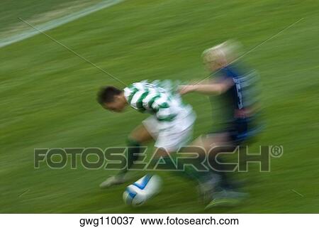 Two players playing soccer in a soccer field View Large Photo Image Stock Photo - Two players playing soccer in a soccer field. Fotosearch