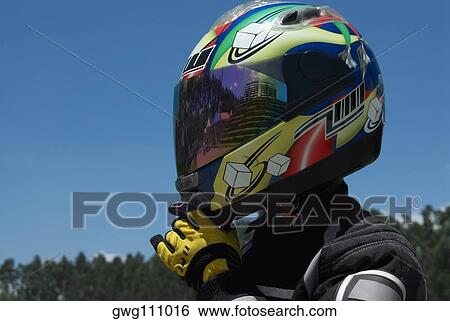 Stock Photograph - Close-up of a person adjusting his crash helmet. Fotosearch