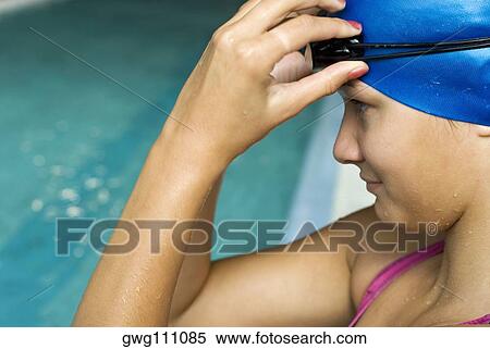 Stock Photography - Close-up of a teenage girl adjusting her swimming goggles. Fotosearch