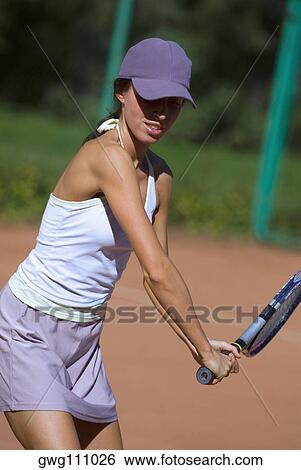 Close-up of a young woman playing with a tennis racket View Large Photo Image Stock Photograph - Close-up of a young woman playing with a tennis racket. Fotosearch