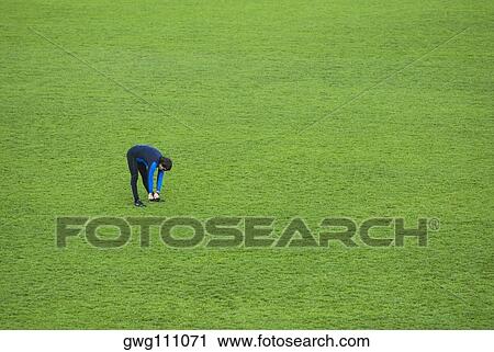 High angle view of a mid adult man exercising in a grassy ground View Large Photo Image Stock Image - High angle view of a mid adult man exercising in a grassy ground. Fotosearch