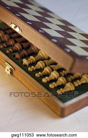 Stock Image - High angle view of chess pieces in a wooden box. Fotosearch
