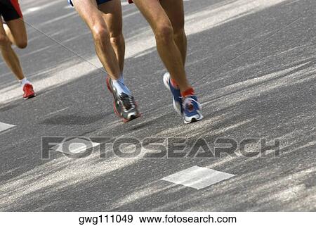 Low section view of three track runners running View Large Photo Image Stock Photo - Low section view of three track runners running. Fotosearch