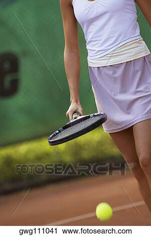 Mid section view of a young woman hitting a tennis ball with a tennis racket View Large Photo Image Stock Image - Mid section view of a young woman hitting a tennis ball with a tennis racket. Fotosearch