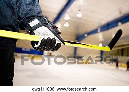 Mid section view of an ice hockey player holding an ice hockey stick View Large Photo Image Stock Photograph - Mid section view of an ice hockey player holding an ice hockey stick. Fotosearch
