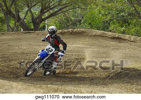 Motocross rider leaning into a turn View Large Photo Image Stock Image - Motocross rider leaning into a turn. Fotosearch
