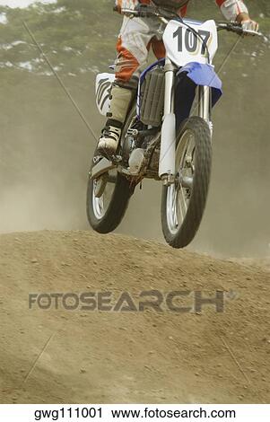 Stock Image - Motocross rider riding a motorcycle. Fotosearch