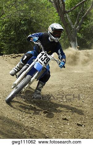Stock Image - Motocross rider riding a motorcycle. Fotosearch