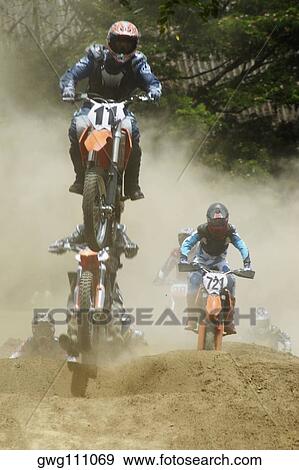 Motocross riders riding motorcycles on a dirt road View Large Photo Image Stock Photo - Motocross riders riding motorcycles on a dirt road. Fotosearch