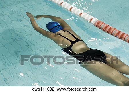 Rear view of a teenage girl swimming in a swimming pool View Large Photo Image Stock Image - Rear view of a teenage girl swimming in a swimming pool. Fotosearch