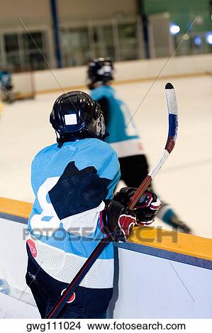 Picture - Rear view of an ice hockey player watching ice hockey. Fotosearch
