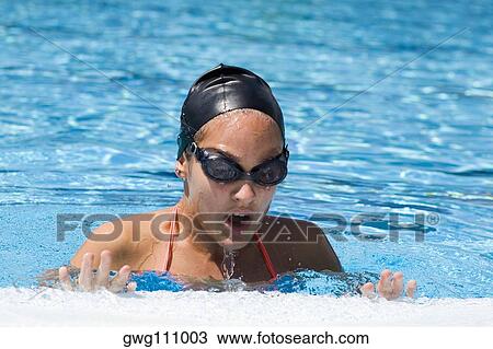 Young woman leaning on the ledge of a swimming pool View Large Photo Image Stock Image - Young woman leaning on the ledge of a swimming pool. Fotosearch